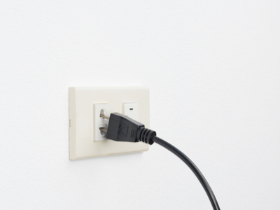 A loose plug slips out of an electrical outlet.